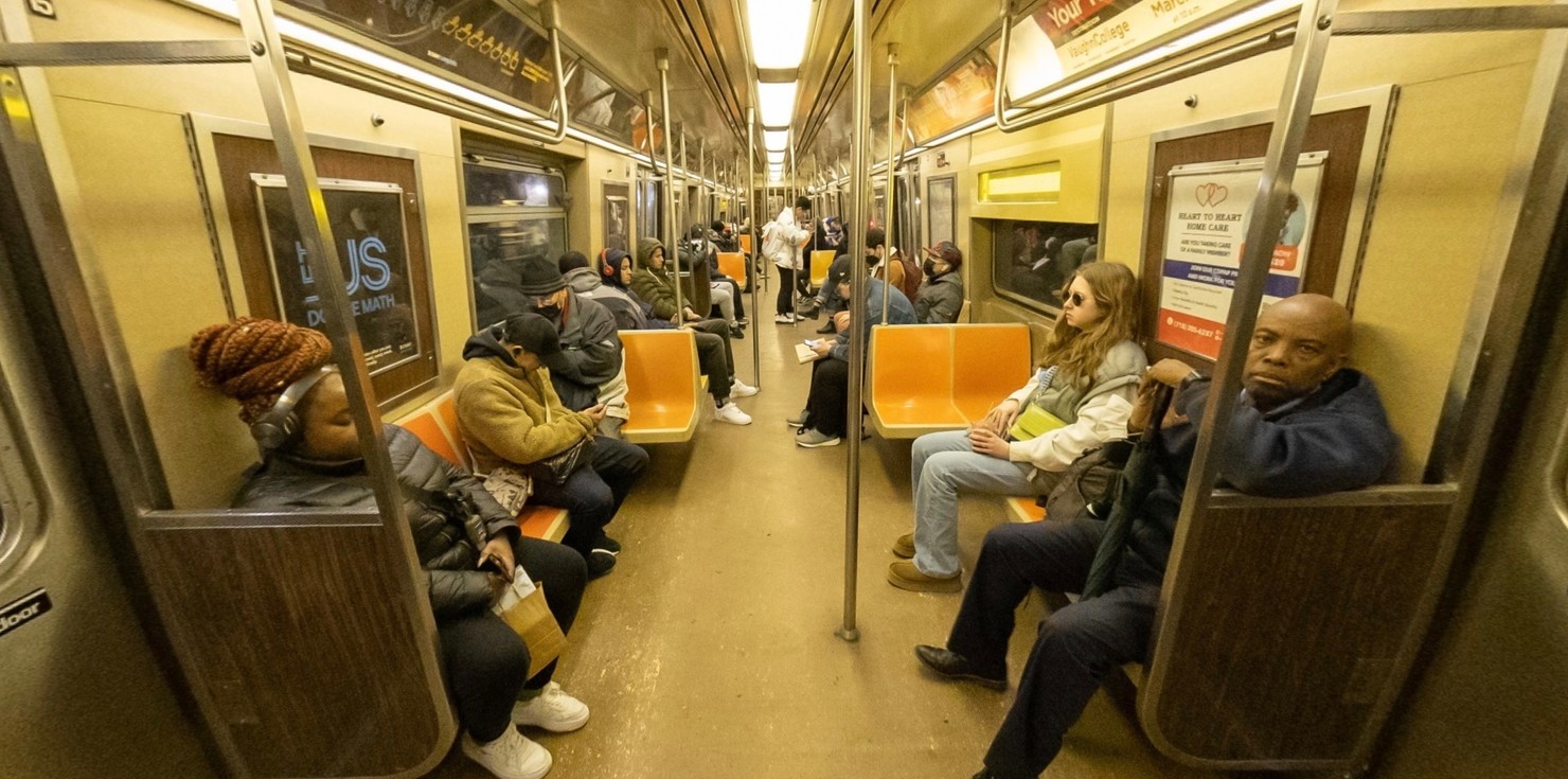 A photograph of a NYC subway car with orange seats..