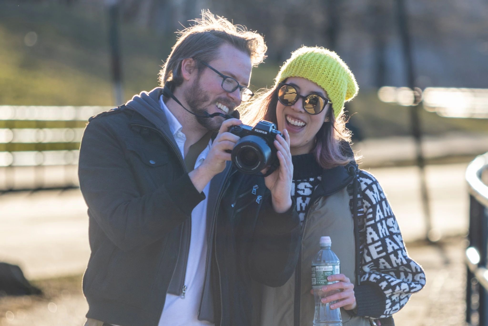 Two people smiling while reviewing a photo on a digital camera's screen.