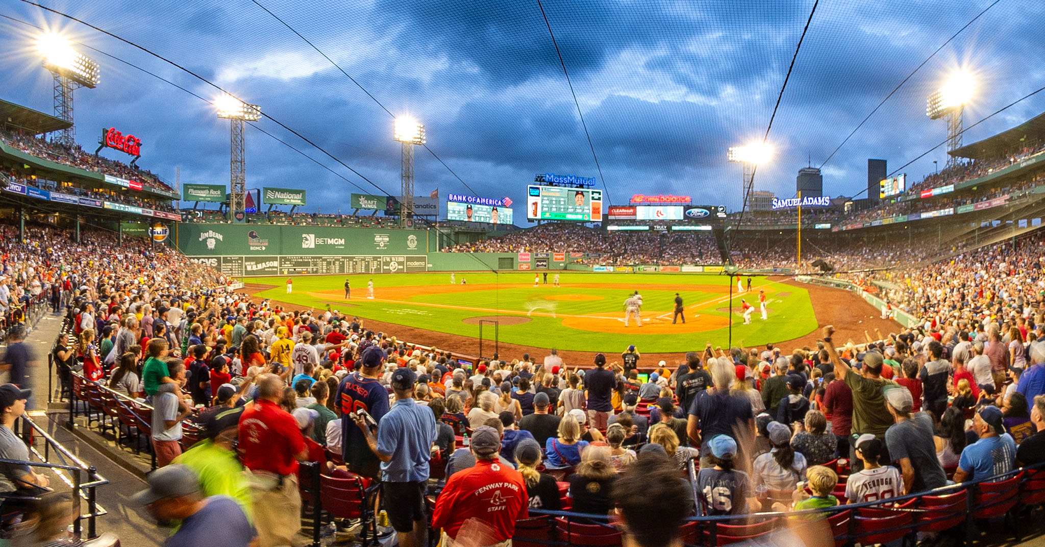 A wide angle photo of a baseball game being played at Fenway Park.