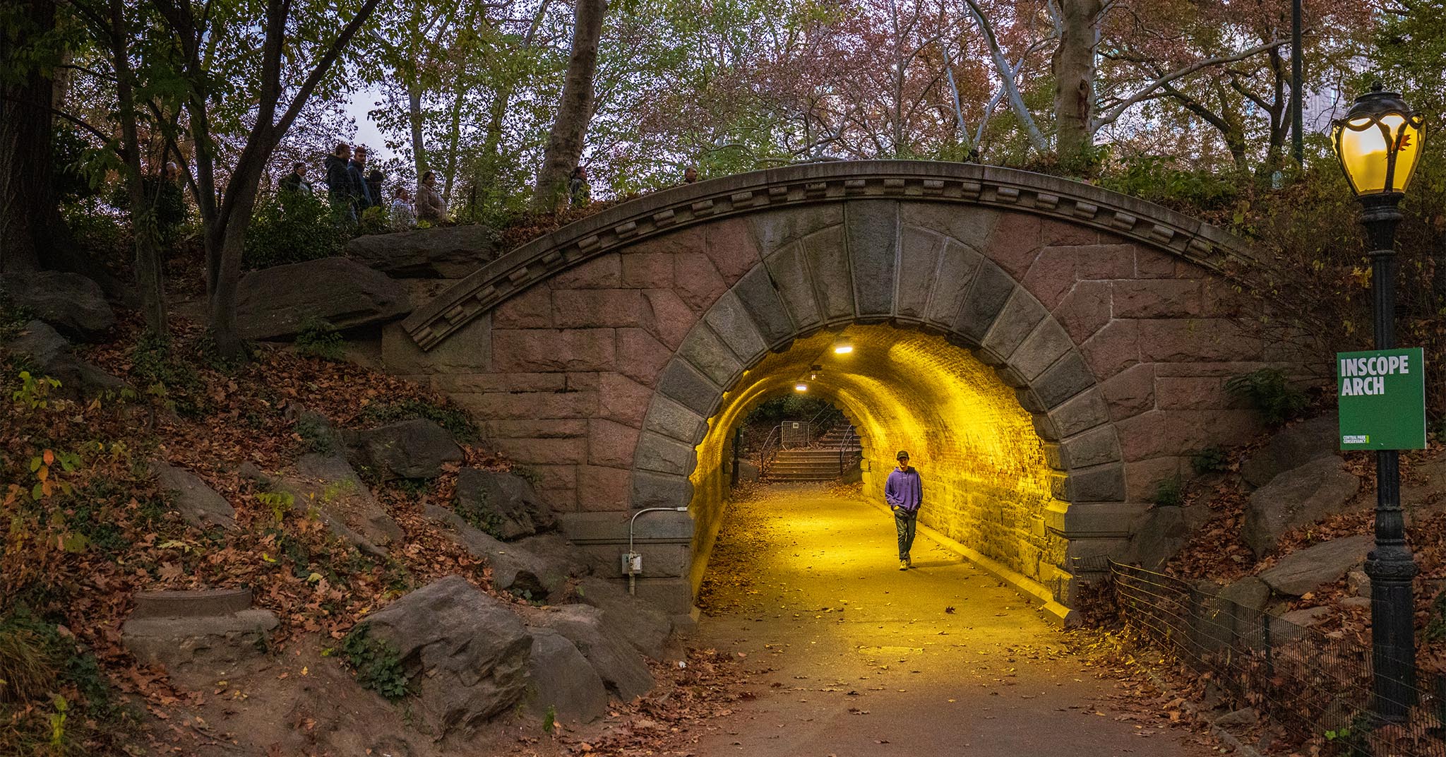 A person walking through Inscope Arch in Central Park, NYC