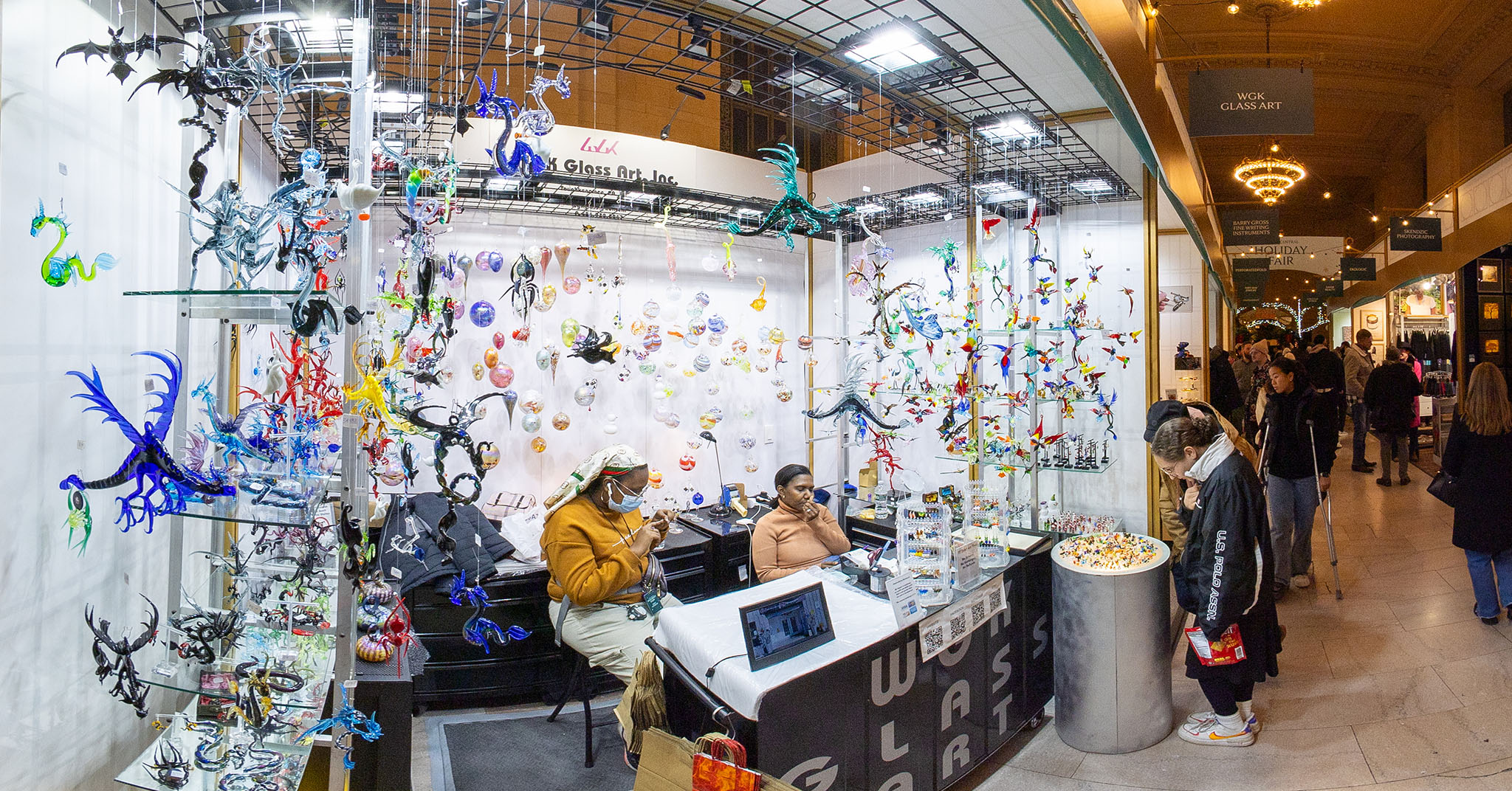 A wide-angle photo of a glass art booth at Grand Central Station's Holiday Fair.