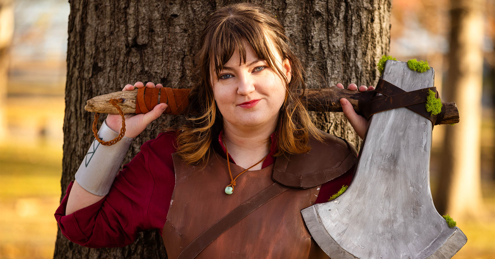 A person in cosplay holding a large, mossy axe.