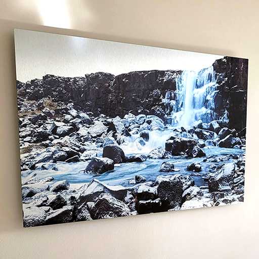 A metal print of a waterfall hung on a wall