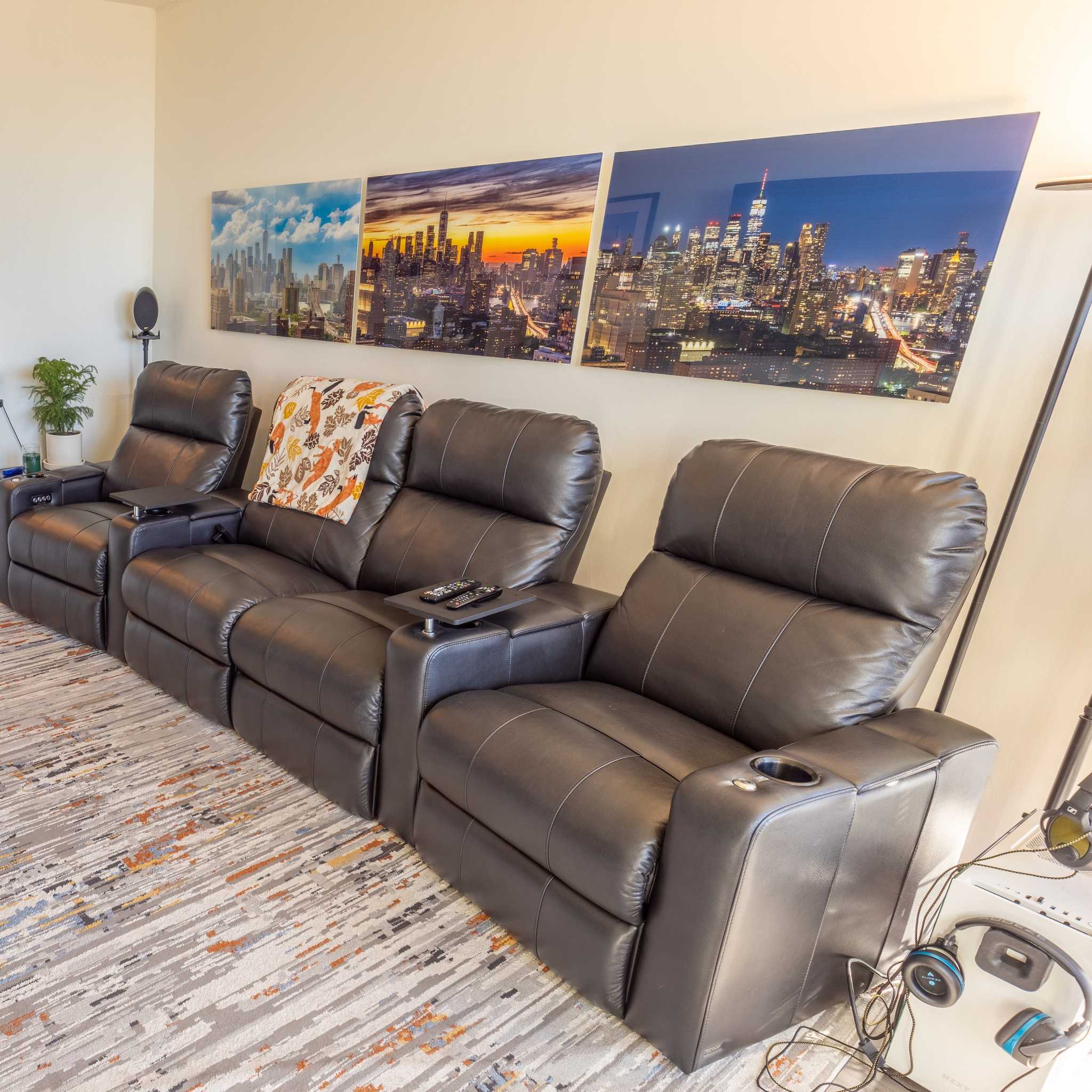 Three acrylic prints of the New York City skyline above leather chairs