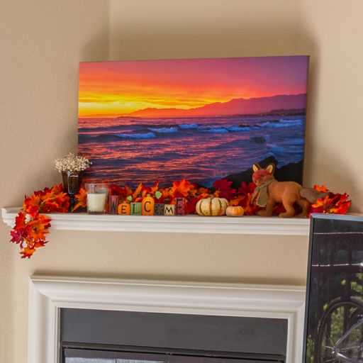 A canvas print of a sunset above a fireplace